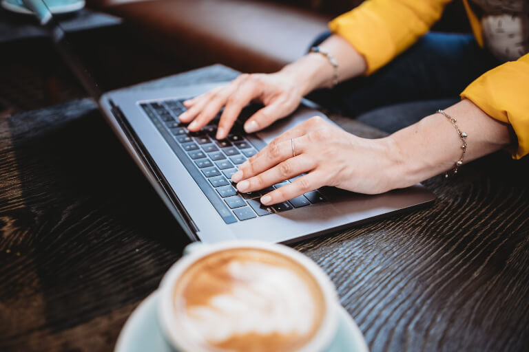 Kvinna som knappar på tangentbordet på en laptop